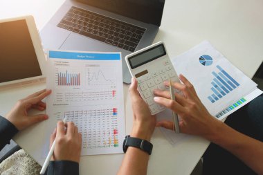 Hesap makinesine basmak için parmaklarını kullanan takım işi. Finansal, muhasebeci..