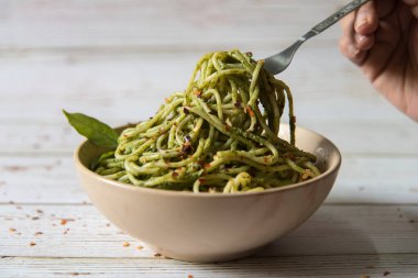 Pesto soslu spagetti makarnası kaseden aşırıldı.