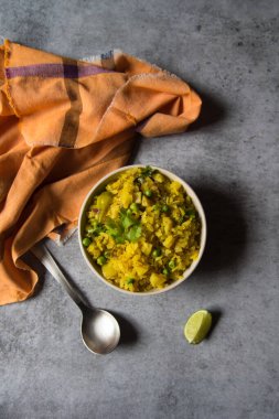 Poha 'nın üst görüntüsü ya da arka planda bir kasede pişmiş pirinç.