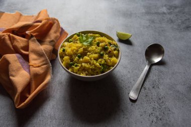 Poha 'ya yakın olmak ya da arka planda bir kasede pirinç ezmek.