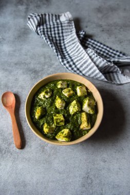 Palak paneer veya süzme peynir küplerinin seçici odaklı ıspanak körisinin üst görüntüsü. 