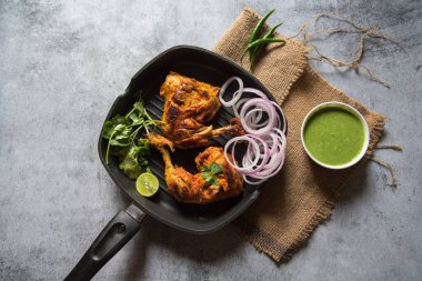 Popüler Hint aperatiflerinin üst görüntüsü tavuk tandırı ve seçici odaklı bir tavada bulunan baharatlar.