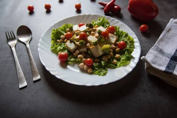  Nohut ve sebze salatasını tabakta peynirli ve seçici odaklı bir tabakla kapat..