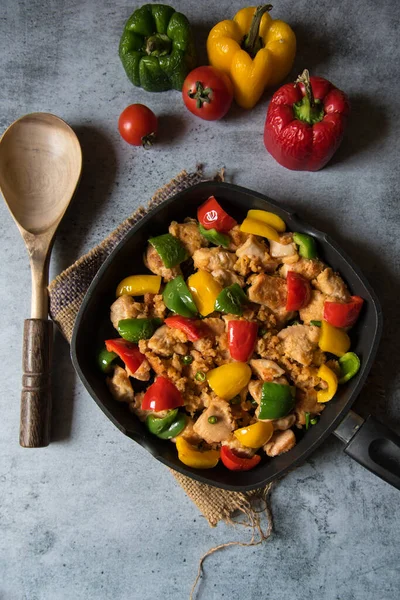 Tavuk ve dolmalık biberin arka planda tavada kızartılmış görüntüsü