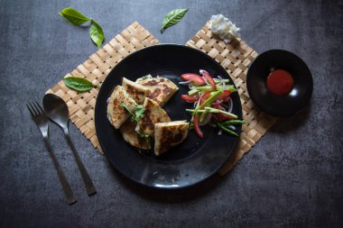 Siyah tabak ve salata soslu Meksika yemeği Quesadilla 'sının en iyi manzarası..