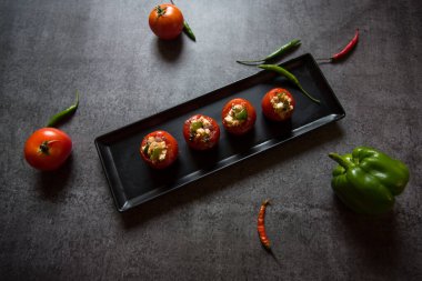 Doldurulmuş domates, içi peynir ve sebzelerle dolu beyaz yağda hazırlanmış bir Hint marşı. Üst görünüm.