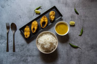 Bengali usulü öğle yemeği menüsünde pilav ve nabızla servis edilen kızarmış balık. Yukarıdan görüntüle, seçici odak.