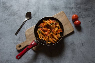 Kırmızı sosta pişirilmiş popüler yemek makarnası. Üst görünüm.