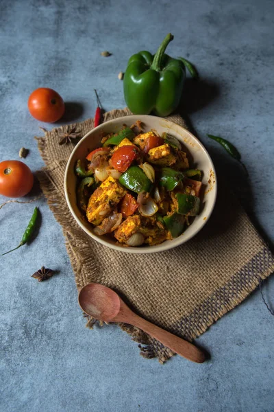 Kadai Paneer, paneer veya süzme peynirli domatesler ve taze baharatlı dolmalık biberlerden yapılan popüler bir Kuzey Hindistan yarı kuru yemeği..