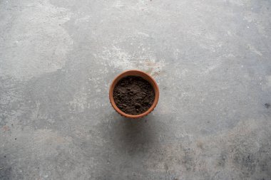 An earthen pot with soil with use of selective focus. Top view, copy space.