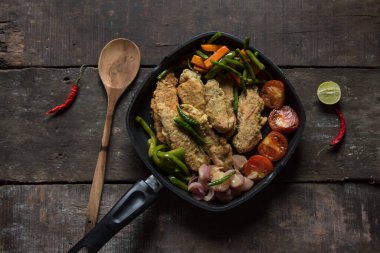 Kızarmış tavuk ve sebze kızartma tavasında sotelenmiş. Üst görünüm.