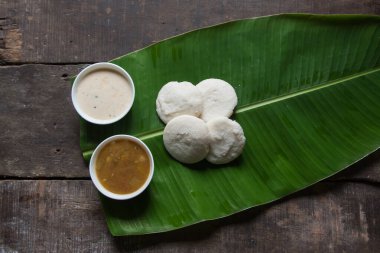 Idli sambar ya da mayalanmış pirinç buharı ile hazırlanmış boş sambhar ve muz yaprağında sunulan hindistan cevizi sosu ve sebze çorbası ile servis edilir..