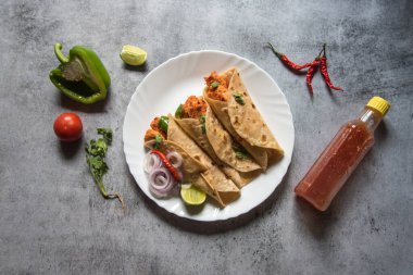 Tortilla ambalajları ya da seçici odaklanma ile servis edilen bir tabakta servis edilen tavuk paketleri. Üst görünüm.