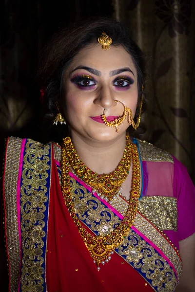 indian bride in traditional dress and ethnic gold ornaments