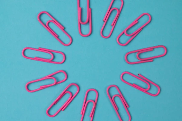 Color paper clips isolated on paper background