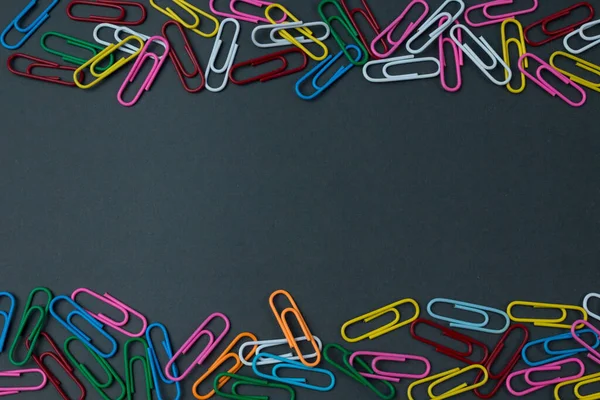 Color paper clips isolated on paper background