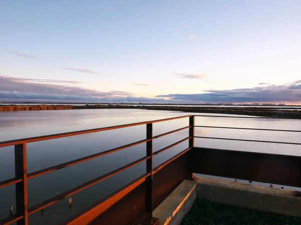 Photo taken from a terrace overlooking a pond during the sunset. — Stock Photo, Image