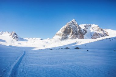 Dağlarda yürüyüş parkurları olan huzurlu kış manzarası. Dağ vadisi manzarasında kayalar, kar ve taşlar. Dağ manzarası.