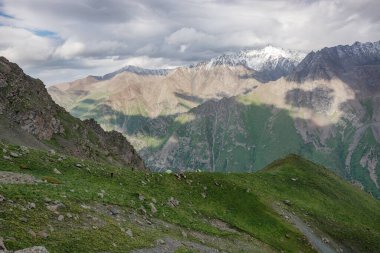 Dağlarda yürüyüş parkurları olan huzurlu kış manzarası. Dağ vadisi manzarasında kayalar, kar ve taşlar. Dağ manzarası.