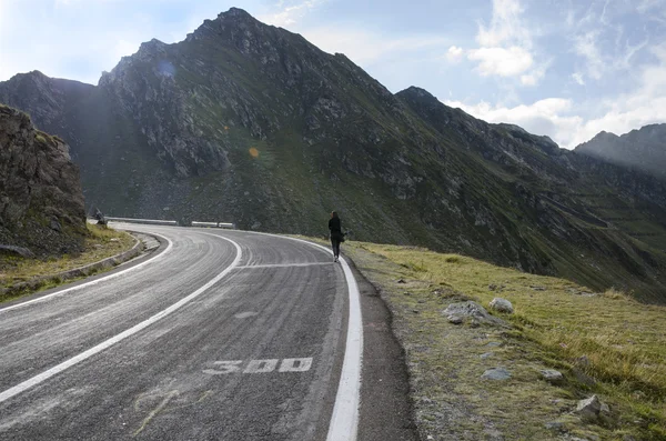 O tânără care merge pe un drum de munte — Fotografie, imagine de stoc