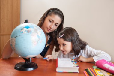 Annesi kızının eğitimine devam ederken yardım