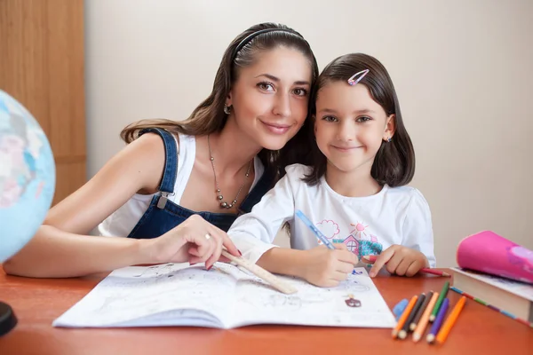 Moeder en dochter doen huiswerk thuis Stockfoto