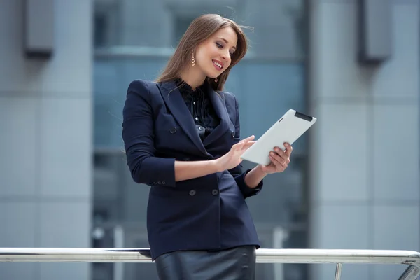 Beautiful businesswoman working with the tablet on the backgroun — Stock Photo, Image