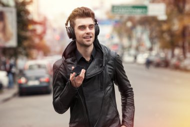 adam sokakta Kulaklığımda. Telefon ile elinde duran