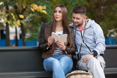 Otobüs durağında oturan turist. İzleyiciler günlüğü
