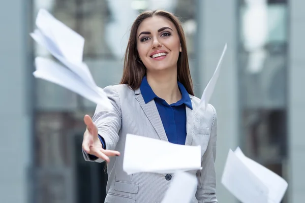 Femme d'affaires jetant des papiers sur le fond de l'entreprise — Photo