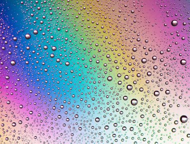 Gökkuşağı arkaplanındaki damlacıklar