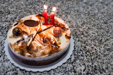 11 numaralı doğum günü mumlu üç çikolatalı pasta ve mesajsız bir çikolata, mermer bir masada doğum günü pastası.