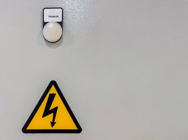 Gerilim mesajı içeren uyarı ışığı ve yüksek voltajlı uyarı sembolü olan gri metal panel, kopyalama alanı, dikey