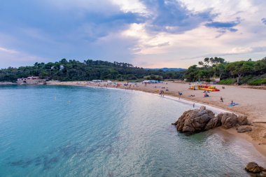 Yaz günü Costa Brava 'da Castelle Sahili' nin panoramik manzarası. Turistik suları ve bulutları gün batımında, Palamos, Girona, İspanya