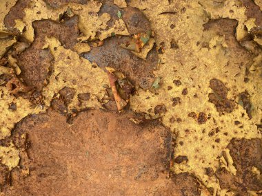 Extreme close-up of a weathered metal surface with peeling yellow paint revealing deep rust and corrosion underneath a vibrant, detailed grunge texture perfect for backgrounds, horizontal