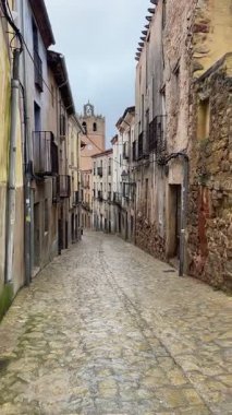 Bir ortaçağ İspanyol köyünde dar bir kaldırım taşı caddesinde yürümek, yağmurdan sonra ıslak taşlar, balkonlu antik taş evler, ve Siguenza, İspanya 'da barışçıl tarihi bir atmosfer, dikey