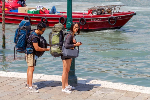 Venedig. Turister med stora ryggsäckar vid vattnet. — Stockfoto