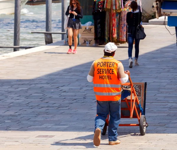 Veneza. Um homem com uma carroça para transportar bagagem . — Fotografia de Stock