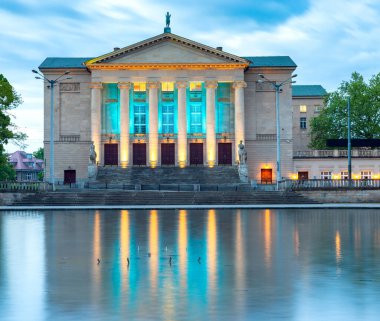 Poznan. Gün batımında parktaki opera evi ve çeşme..