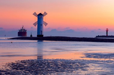Swinoujscie. Güneş doğarken ünlü yel değirmeni deniz feneri.