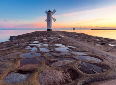 Swinoujscie. Güneş doğarken ünlü yel değirmeni deniz feneri.