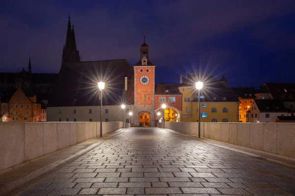 Regensburg. Old stone bridge over the Danube river in the night light. — Stock Photo, Image