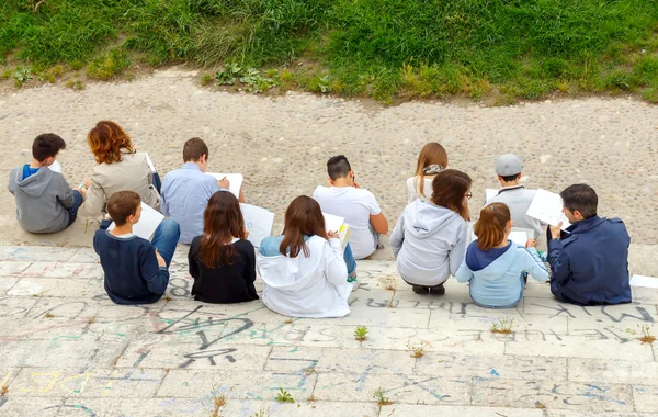 Children on the waterfront Verona paint a bridge.