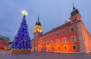 Şafak vakti Polonya 'nın Kale Meydanı' nda tarihi binalarla aydınlatılmış Noel ağacı.