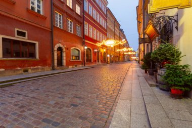 Varşova Polonya 'nın eski kasaba meydanında kış akşamı aydınlatılmış Noel süsleri ve tarihi binalar
