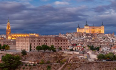 Günbatımında Toledo, İspanya 'nın panoramik manzarası, dramatik bulutlar, tarihi binalar, Toledo' nun Alcazar 'ı ve eski şehrin ufuk çizgisine doğru parladı..