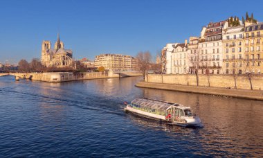 Tarihi bir katedral manzarası ve Paris 'teki Ile de la Cite' deki Seine nehri. Fransa 'nın gotik mimarisi ve sıcak akşam ışığı ile.