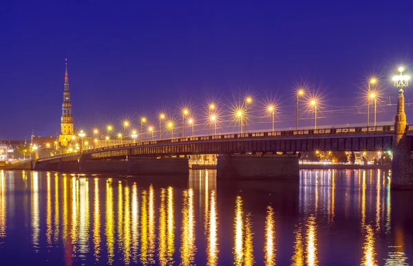 Riga. A ponte do outro lado do rio Daugava à noite . — Fotografia de Stock