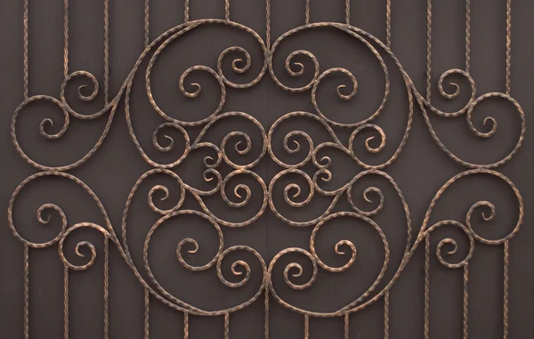 Forged item on gates on dark background — Stock Photo, Image