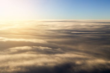 Sabah vakti uçağın penceresinden bulutlar görünüyor..